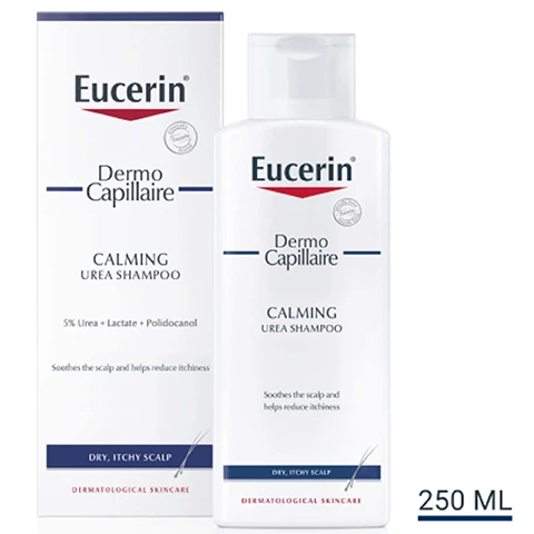 Image 1 - A bottle and box of Eucerin Dermo Capillaire Calming Urea Shampoo, with the bottle showing the product name, key ingredients, and benefits while the box prominently displays the same information.
Image 2 - A woman smiles while holding a bottle of Eucerin calming cleansing and displaying a list of key benefits: helps ease itching and irritation, relieves dryness, fragrance-free.
Image 3 - A hand holds a bottle of Eucerin Dermo Capilaire Calming Ultra Medi Shampoo on the left, while the right side features three icons with the text: Moisturising, Anti-itch, Fragrance-free.
Image 4 - Blue background with the text Consumers Confirm, Soothes the Scalp and Reduces the Itchiness, and a note about product testing with details regarding patients and conditions.
Image 5 - An image showing two Eucerin products: a bottle labeled Dermo Capillaire Calming Urea Scalp Treatment and another labeled UreaRepair Plus 10% Urea Lotion, with the text DISCOVER MORE at the top.
Image 6 - A woman applies a product to her scalp with one hand while looking to the side, and the image includes text that reads USE UP TO TWICE DAILY, MORNING AND EVENING, WITH OR WITHOUT WASHING HAIR FIRST and HOW TO USE.