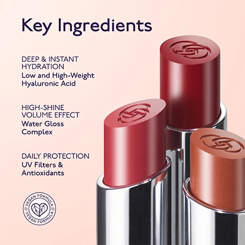 Image 1 - Three lipsticks in red and brown shades with silver bases and embossed logos are displayed on a pink background next to text that reads Key Ingredients DEEP & INSTANT HYDRATION Low and High-Weight Hyaluronic Acid HIGH-SHINE VOLUME EFFECT Water Gloss Complex DAILY PROTECTION UV Filters & Antioxidants and a circular logo stating VEGAN FORMULA. Image 2 - A brown-toned By Terry lip and cheek balm stick in a silver and dark purple tube is centered on a light pink background surrounded by creamy swatches of various nude and pink shades, with visible text including BY TERRY, 94% SKINCARE-INFUSED, USE ON LIPS & CHEEKS, CREAMY, NON-STICKY FORMULA, and HYDRATING & COMFORTING. Image 3 - The image shows a By Terry Shade Finder with six lip products, each accompanied by a color swatch and its name: Sexy Nude, Nudissimo, Tea Time, Dare To Bare, Secret Kiss, and Love Affair.
