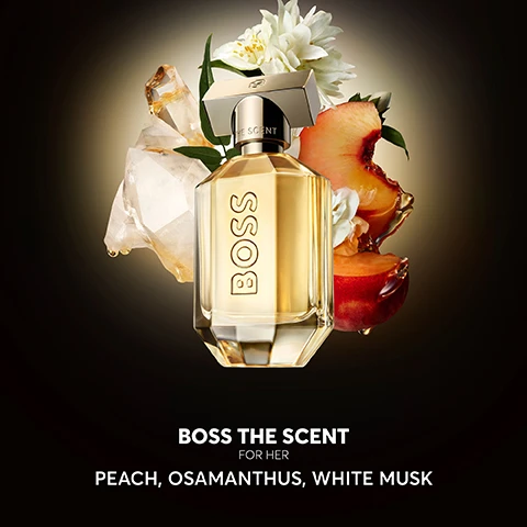 Image 2 - A perfume bottle labeled BOSS THE SCENT FOR HER is surrounded by peach slices, white flowers, and crystal-like elements, with the text PEACH, OSAMANTHUS, WHITE MUSK below.
Image 3 - A perfume bottle labeled BOSS THE SCENT is prominently displayed on a reflective surface with text indicating new and old bottle designs.
Image 4 - A sleek perfume bottle with rose gold detailing is displayed against a dark background, featuring the word BOSS prominently, along with a quote praising the scents elegance and floral notes, and a five-star rating at the bottom.
Image 5 - A display of four perfume bottles labeled BOSS, with descriptions for each: Eau de Parfum, Magnetic Eau de Parfum, Parfum, and Elixir, accompanied by scent family and notes below.
Image 6 - A man and woman pose together, both dressed in stylish black outfits, next to two bottles of the BOSS THE SCENT fragrance, with visible text reading BOSS THE SCENT and THE NEW REFILLABLE FRAGRANCES.
Image 8 - Image shows a BOSS The Scent perfume bottle positioned on a black surface, with text stating that refilling the bottle reduces packaging impact by 54% greenhouse gas emissions, 56% fossil resource use, and 62% land use, along with a footnote regarding life cycle assessment standards.