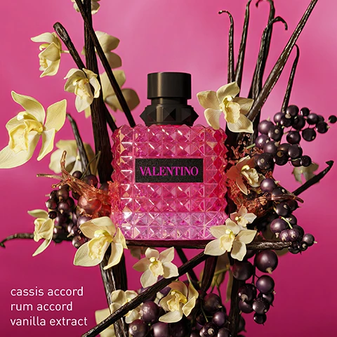Image 1 - A pink, textured perfume bottle labeled VALENTINO is surrounded by white flowers and dark berries, with visible text listing cassis accord, rum accord, and vanilla extract.
Image 2 - Three pink and black perfume bottles are displayed among light-colored flowers, labeled from left to right as follows: Born in Roma, Born in Roma Intense, and Born in Roma Extradosé, with descriptions of each fragrances notes beneath the bottles: Sambac Jasmine, Cashmeran, Vanilla; Vanilla, Jasmine, Benzoin Resin; Cassis Accord, Rhum Accord, Vanilla Extract.