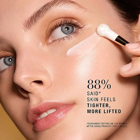 Image 1 - A close-up of a woman applying a cream to her cheek with a small applicator, showing her clear skin, blue eyes, and a subtle smile, with visible text stating 88% SAID* SKIN FEELS TIGHTER, MORE LIFTED *CONSUMER TESTING ON 128 WOMEN AFTER USING PRODUCT FOR 4 WEEKS.