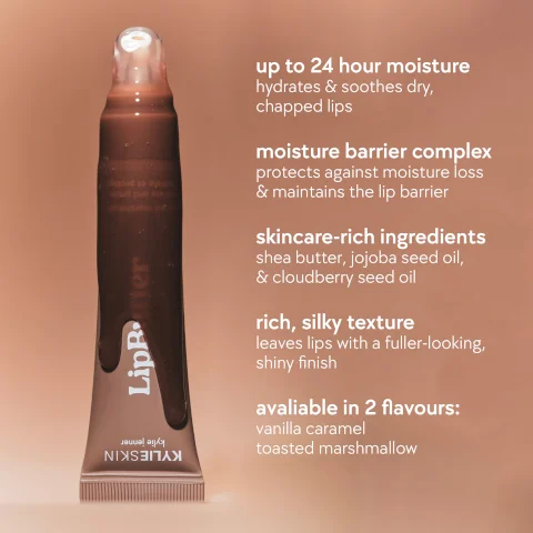 Image 1 - A tube of lip balm labeled Lip Butter stands upright, with a brown gradient background and text that includes details on its benefits and flavors: up to 24 hour moisture hydrates & soothes dry, chapped lips, moisture barrier complex protects against moisture loss & maintains the lip barrier, skincare-rich ingredients shea butter, jojoba seed oil, & cloudberry seed oil, rich, silky texture leaves lips with a fuller-looking, shiny finish, available in 2 flavours: vanilla caramel, toasted marshmallow.