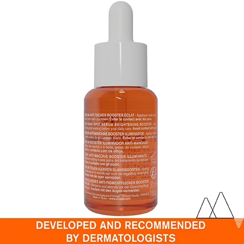Image 1 - A brown glass dropper bottle containing a brightening serum with text in multiple languages on the label, and a bold orange banner at the bottom that reads DEVELOPED AND RECOMMENDED BY DERMATOLOGISTS.
Image 2 - A close-up of a persons cheek with a drop of serum being applied, featuring text labels that read lightweight serum, non-greasy & non-sticky, and dark spots - dull complexion even sensitive.
Image 3 - A young woman smiles while holding a bottle of Uriage Dépiderm serum, which is labeled with text about reducing dark spots in 28 days and its radiance-boosting effect.
Image 4 - An infographic detailing an advanced dermatological formula includes sections labeled Mela Technology with a description about dark spot correction, 20% Vitamin C Complex emphasizing high tolerance for sensitive skin, and Niacinamide highlighting its soothing properties, all set against a light blue background.
Image 5 - A scenic image of snow-capped mountains reflecting in a lake with text overlay indicating the product is recommended by dermatologists, suitable for sensitive skin, non-comedogenic, fragrance-free, and composed of 94% ingredients of natural origin.
Image 6 - A bottle of Uriage Dépiderm anti-dark spot serum with a dropper, featuring a blue circular badge stating Developed by Dermatologists, alongside text in French and English indicating its purpose as a brightening booster for dark spots and dull complexion.