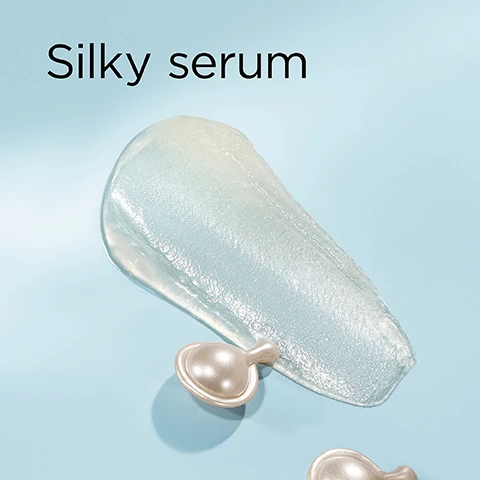 Image 1 - A shimmering clear serum streak is on a light blue background with two pearl-colored capsules, with the text Silky serum. Image 2 - The image displays a scientific or cosmetic visual against a light blue and white background, featuring clear spherical droplets, water drops, and a network of interconnected beads, with text labels reading Phytoceramides nourish & strengthen, Size-Shifting HA plumps & fills, and Peptides firm & volumize. Image 3 - A smiling blonde woman with blue eyes holds a clear bottle filled with Elizabeth Arden skincare capsules, with large text overlaying the image that reads 100% show instantly plumper skin*, the bottle label reads Elizabeth Arden NEW YORK HYALURONIC ACID + PEPTIDES Ceramide Capsules Hydra-Plumping Serum Sérum Hydratant Repulpant, and a smaller disclaimer at the bottom states *Based on a clinical study of 33 panelists immediately after use. Image 4 - An Elizabeth Arden product image displays a clear bottle of pearl-colored, teardrop-shaped capsules, a chrome applicator tool, and overlay text that reads Why HA + Peptides? Hyaluronic Acid plumps, Peptides firm, the key to plumper, bouncier skin. The bottle label also shows Elizabeth Arden NEW YORK HYALURONIC ACID + PEPTIDES Ceramide Capsules Hydra-Plumping Serum Sérum Hydratant Repulpant. Image 5 - A before and after image of a womans face shows her skin appearing smoother and plumper in the after shot, with the text Before, After, Skin looks plumper.