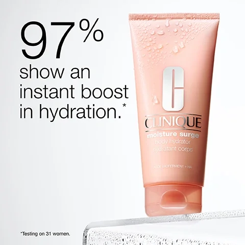 Image 5 - A light pink Clinique moisturizer tube covered in water droplets sits on a clear wet surface with a white background, displaying the text 97% show an instant boost in hydration. *Testing on 31 women. CLINIQUE moisture surge body hydrator hydratant corps ALOE BIOFERMENT + HA.