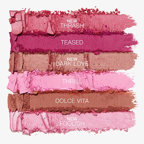 Image 1 - Six textured swatches of cosmetic powders are displayed vertically: shimmering pink NEW THRASH, fuchsia TEASED, shimmering bronze-pink NEW DARK LOVE, pale pink THRILL, matte brown DOLCE VITA, and shimmering pale pink NEW FOOLISH. Image 2 - Makeup swatches in various shades of pink, brown, and red are displayed in horizontal stripes on three arms with light, medium, and dark skin tones, labeled Foolish, Thrash, Dark Love, Thrill, Teased, and Dolce Vita.