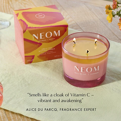 Image 1 - A NEOM Great Day Scented Candle in a pink glass jar with three lit wicks is shown next to its box featuring orange graphics, with visible text on the box and candle NEOM WELLBEING LONDON GREAT DAY SCENTED CANDLE 420 g e 14.8 oz. Net Wt. and additional text below the image Smells like a cloak of Vitamin C – vibrant and awakening ALICE DU PARCQ FRAGRANCE EXPERT. Image 2 - A pink candle with three wicks has the text UPLIFT YOUR DAY AND BOOST YOUR MOOD A complex blend of 7 pure essential oils 100% natural fragrances 100% naturally derived wax NEOM WELLBEING | LONDON.