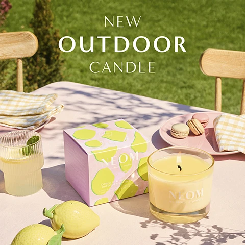 Image 1 - An outdoor table setting with a lit NEOM Complete Bliss Outdoor Candle, its box, decorative lemons, a drink, and macarons, under the overlaid text NEW OUTDOOR CANDLE. Image 2 - A lit yellow candle in a glass jar and its pink box with green abstract shapes are shown on a table with the text NEOM WELLBEING LONDON COMPLETE BLISS OUTDOOR SCENTED CANDLE Mandarin Bergamot Citronella 420g e Net Wt 14.8oz on the box, NEOM WELLBEING LONDON on the jar, and Smells like a summer floral wrapped in a citrus breeze below. Image 3 - A glass jar candle with yellow wax and a label that reads NEOM WELLBEING | LONDON, with text above it that reads A CALMING HAVEN FOR YOUR OUTDOOR SPACES Blended with 20 pure essential oils including citronella 100% natural fragrances 100% naturally derived wax.