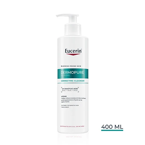 Image 1 - A white bottle with a pump dispenser is shown, labeled Eucerin BLEMISH-PRONE SKIN DERMOPURE CLINICAL CORRECTING CLEANSER with 2% SALICYLIC ACID BHA + AHA + PHA INTENSE, which helps reduce excess oil, blemishes and appearance of post-acne dark marks, SUITABLE FOR SENSITIVE SKIN FACE & BODY, DERMATOLOGICAL SKINCARE, and a capacity of 400 ML. Image 10 - The image shows three Eucerin skincare products arranged vertically with numbers 1, 2, and 3 above each, and the Eucerin logo at the top right; product 1 is a white pump bottle labeled Eucerin Blemish-Prone Skin Dermopure Clinical Correcting Cleanser with text 2% Salicylic Acid AHA + BHA + PHA, Intense, Reduces impurities, blemishes and appearance of post-acne dark marks, Suitable for sensitive skin, Face & Body, Dermatological Skincare, used day and night; product 2 is a smaller white pump bottle labeled Eucerin Dermopure Clinical Triple Action with text 2% Salicylic Acid, used day and night; product 3 is a white and orange bottle labeled Eucerin 50+ Oil Control Dry Touch Sun Gel-Cream Ultra Light, used during the day. Image 2 - A person dispenses clear liquid from a white Eucerin DermoPure Correcting Cleanser bottle for acne-prone skin into their hand, with accompanying text describing it as FOAMING GEL, NON-COMEDOGENIC, and SUITABLE ON SENSITIVE SKIN. Image 3 - A person with blonde curly hair applies white foamy cleanser to their cheek, with the text Eucerin Intensive Cleansing Gel CORRECTS BLEMISHES & MARKS FROM STEP 1. Image 4 - A woman with braided hair and a dark top holds a white Eucerin pump bottle, with the Eucerin logo at the top right of the image, and text visible including Eucerin, Face & Body Efficacy, EXCESS SEBUM, PIMPLES, COMEDONES, MARKS, and text on the bottle reading Eucerin, BLEMISH-PRONE SKIN, DERMOPURE CLINICAL CORRECTING CLEANSER, 2% SALICYLIC ACID BHA + AHA + PHA, INTENSE, Helps reduce excess oil, blemishes & the appearance of post-acne dark marks, Suitable for sensitive skin, FACE & BODY, DERMATOLOGICAL SKINCARE. Image 5 - The image displays three white Eucerin DermoPure Correcting Cleanser pump bottles arranged in decreasing size from left to right on a white background, with visible text Eucerin ACNE-PRONE SKIN DERMOPURE CLINICAL CORRECTING CLEANSER 2% SALICYLIC ACID BHA + AHA + PHA INTENSE Reduces excess oil and blemishes Corrects post-acne marks SENSITIVE SKIN FACE & BODY DERMATOLOGICAL SKINCARE 96% SAW BLEMISHES & POST-ACNE MARKS REDUCTION¹ ¹ Product-in-use, 100 subjects, after 4 weeks. Image 6 - A side-by-side comparison of an old and new Eucerin Dermopure bottle, with the old bottle on the left blurred and the new bottle on the right in focus, alongside the text NEW LOOK SAME FORMULA, Eucerin, OLD, and NEW. Image 7 - A person in a white lab coat holds a Eucerin DermoPure Correcting Cleanser bottle, with the text Recommended by Dermatologists for Oily to Blemish-Prone Skin and the bottle label displaying Eucerin, Blemish-Prone Skin, DermoPure Clinical, Correcting Cleanser, 2% Salicylic Acid BHA + AHA + PHA, Intense, Helps reduce excess oil, blemishes and appearance of post-acne dark marks, Suitable for Sensitive Skin, Face & Body, Dermatological Skincare. Image 8 - The image shows a teal liquid surface with ripples at the top and white space with text below, displaying Eucerin logo and the text With correcting SALICYLIC ACID, Dissolves & removes dead skin, Opens up and prevents clogged pores. Image 9 - A split image showing a teal, wavy liquid on the left and a clear, viscous liquid on the right, with the Eucerin logo at the top right, and text that reads 2% Salicylic Acid To exfoliate and unclog blocked pores, Dermo Acids AHA & PHA To significantly enhance the skins appearance.