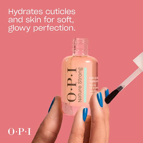 A hand with blue nail polish holds a clear bottle of OPI Nature Strong nail and skin oil with its brush applicator, against a pink background, with the text Hydrates cuticles and skin for soft, glowy perfection. OPI Nature Strong, Nails & Skin, Ongles et Peau, Glow Up, Nail & Cuticle, Huile Éclat Ongles et Cuticules.