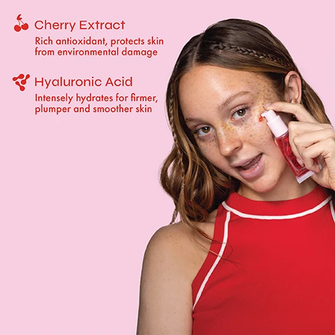 Image 2 - A young woman with freckles applies a red serum to her cheek from a pink bottle, against a pink background with text that reads: Cherry Extract, Rich antioxidant, protects skin from environmental damage, Hyaluronic Acid, Intensely hydrates for firmer, plumper and smoother skin. Image 3 - A hand holds a pink tube of The Beauty Crop Oui Cherie Gripping Primer with a red cherry beside it, and text callouts reading Hydrates skin, Suitable for blemish-prone skin, and Ultra-gripping formula that locks in makeup all day, with the primer label also stating Hydrating Gripping Primer, Base Teint Hydratante & Accrochante, Formulated with Cherry Extract & Hyaluronic Acid, Formulée avec de l’extrait de Cerise & de l’acide hyaluronique, 20ml e 0.70 fl.oz.